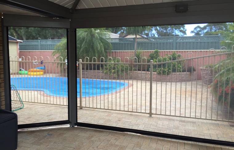 outdoor blinds installed in patio by the pool
