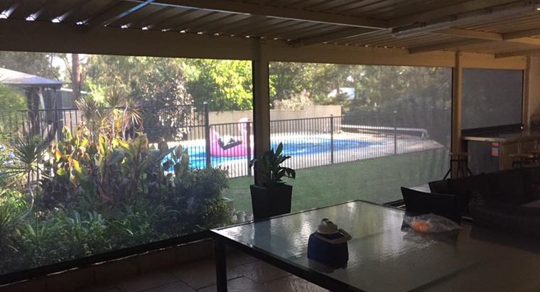 view from the patio through the blinds to the pool